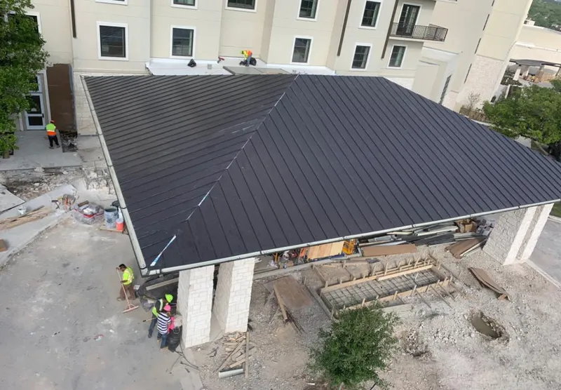 Metal roofing installation team working on a commercial building in Eden